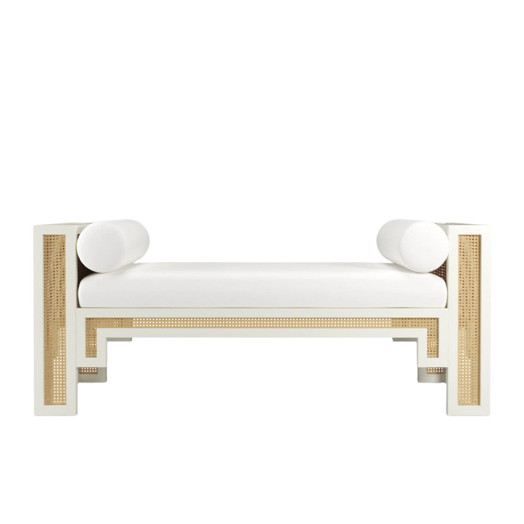 White upholstered 59-inch end-of-bed bench featuring natural rattan cane panels, painted solid wood frame and two cylindrical white bolster pillows in a boho-Scandinavian style.