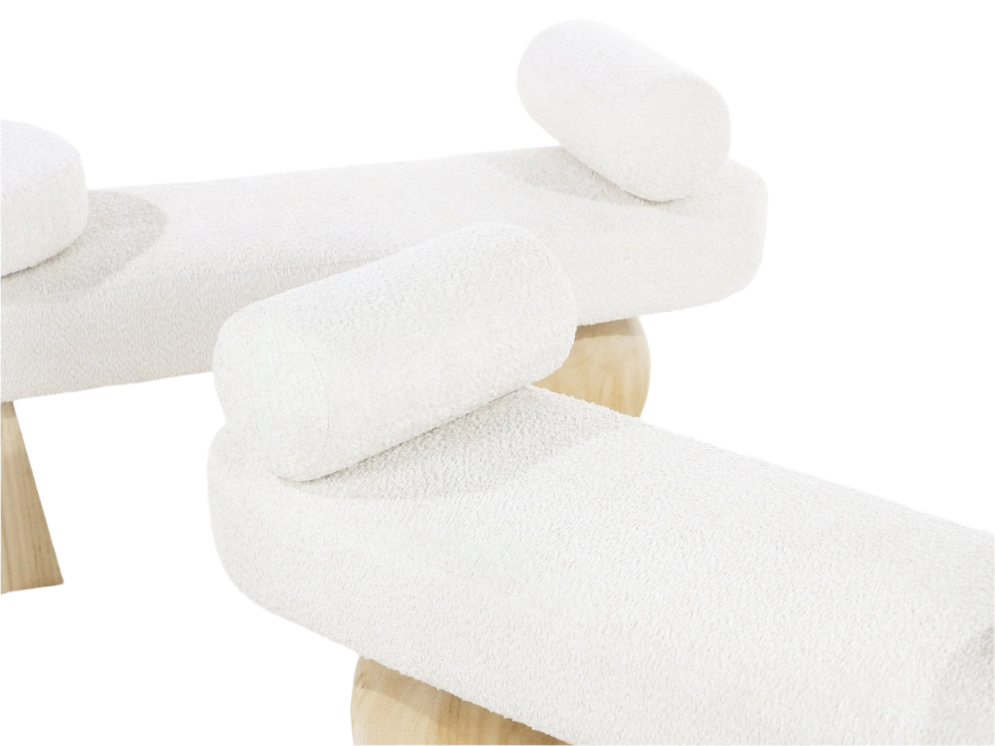Close-up of a cream boucle upholstered end-of-bed bench showing textured fabric, cylindrical bolster cushions and rounded light solid-wood legs.