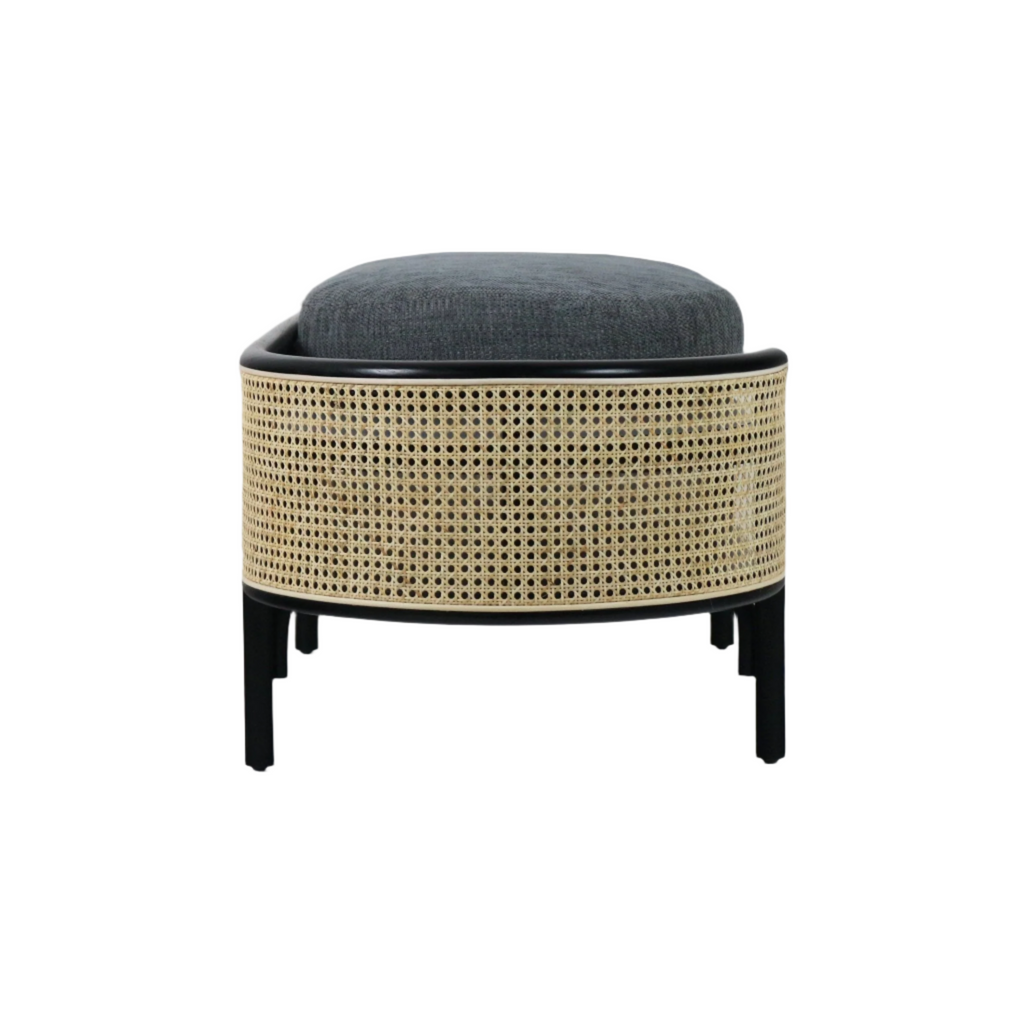 Front view of a solid wood bench with natural rattan cane sides, black wood frame and legs, and a dark gray upholstered cushion, styled with a modern boho look suitable for bedroom or entryway seating.