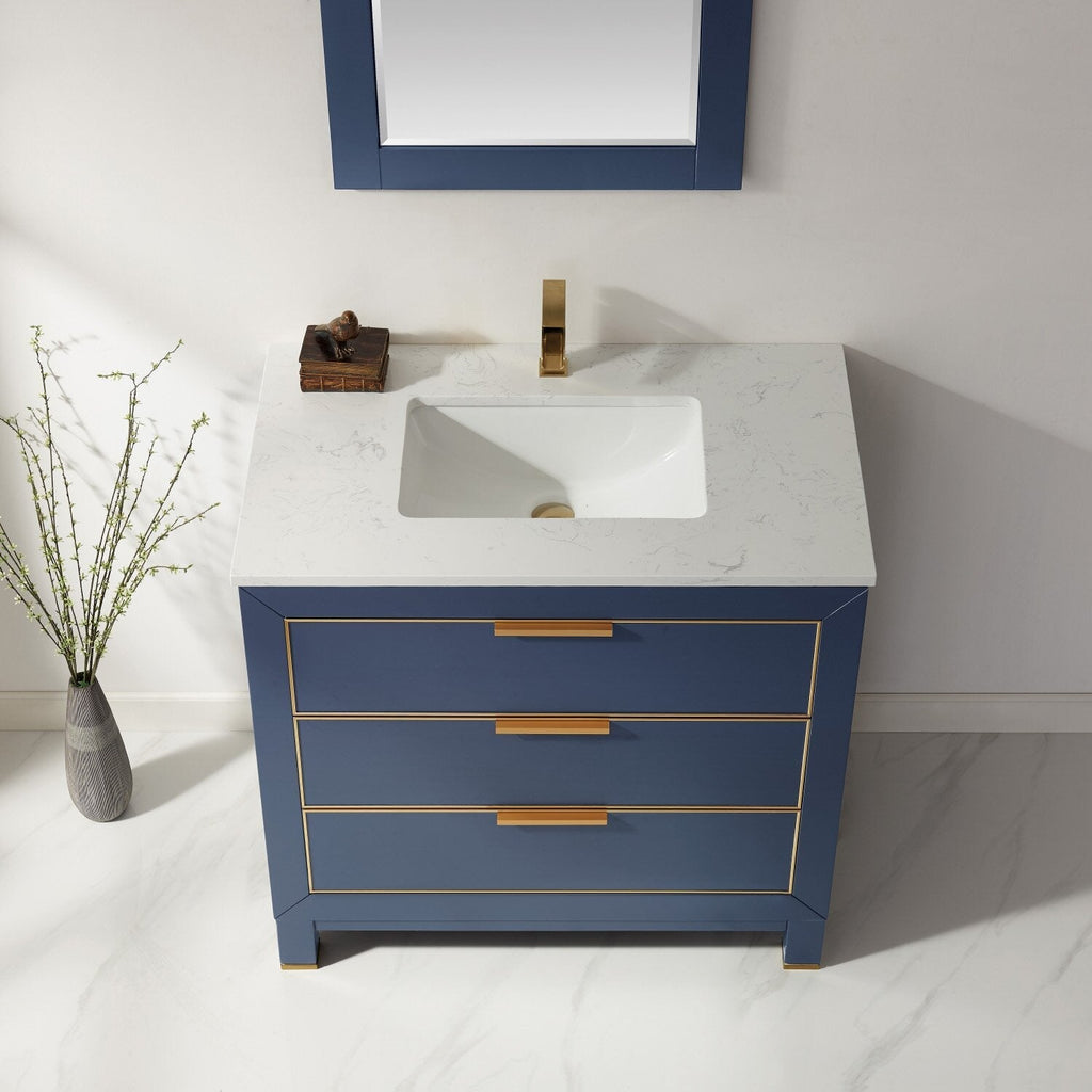 Modern solid wood 36-inch bathroom vanity in navy blue with a white stone countertop, integrated ceramic sink, and brass/gold faucet and drawer hardware with three drawers.