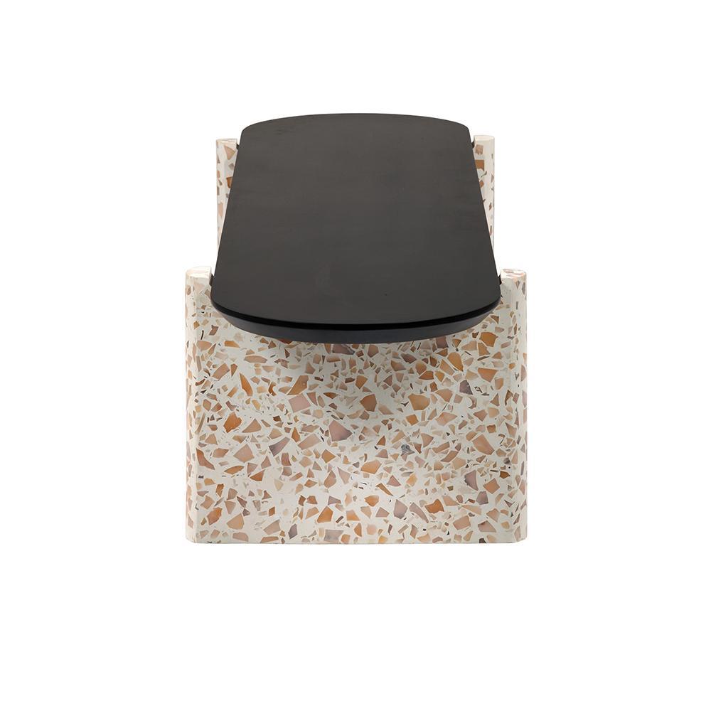 Front view of a modern coffee table with a black mahogany oval wood top mounted on a cream terrazzo block base patterned with tan and brown stone chips.