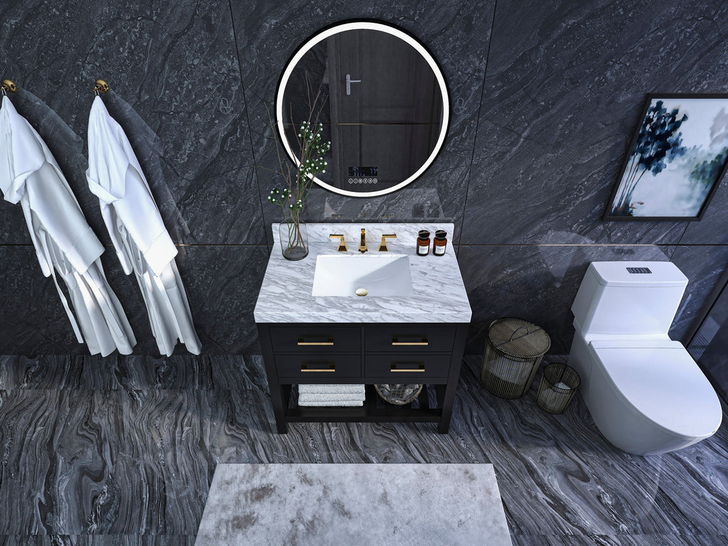 Modern 36-inch solid wood black single-sink vanity with a white rectangular undermount sink in a marble stone top, gold faucet and drawer pulls, open towel shelf, round illuminated mirror and dark stone walls and floor.