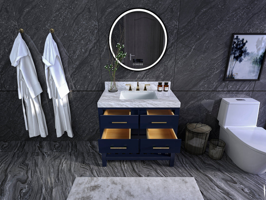 36-inch modern solid wood single-sink vanity with a stone marble top, navy painted freestanding base, four open drawers with brass pulls, rectangular undermount ceramic sink and brass faucet, set against dark stone tile with round mirror.