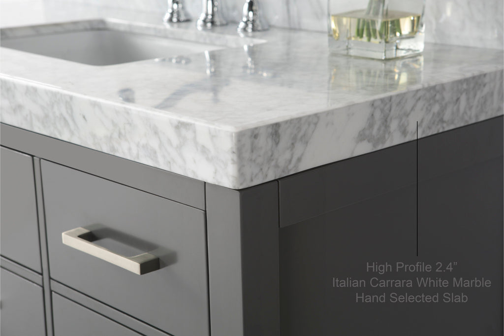 Close-up of a 2.4-inch Italian Carrara white marble countertop on a stone-colored solid wood modern vanity, showing the corner, undermount sink edge, chrome faucet reflection and brushed nickel rectangular drawer handle.
