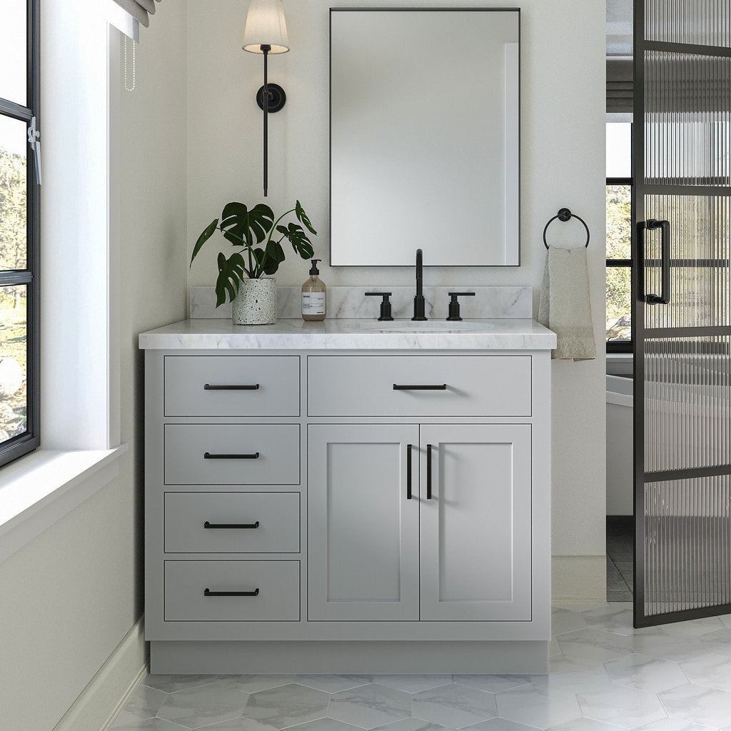 Freestanding 43-inch modern solid wood bathroom vanity in stone finish with white stone countertop, ceramic single sink, matte-black widespread faucet and hardware, four drawers and double-door cabinet under a rectangular mirror.