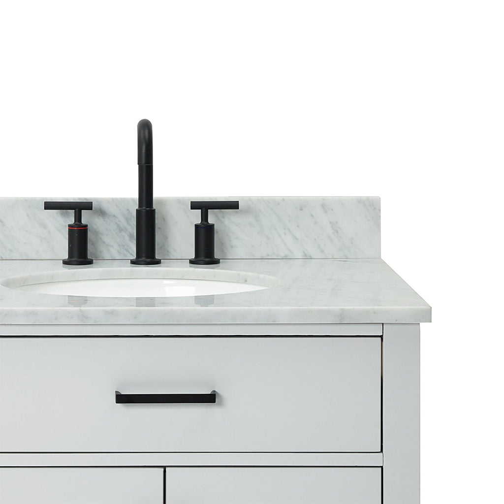 Close-up of a modern solid wood bathroom vanity with a white veined quartz countertop, oval undermount sink, matte black widespread faucet and matching black drawer handle.