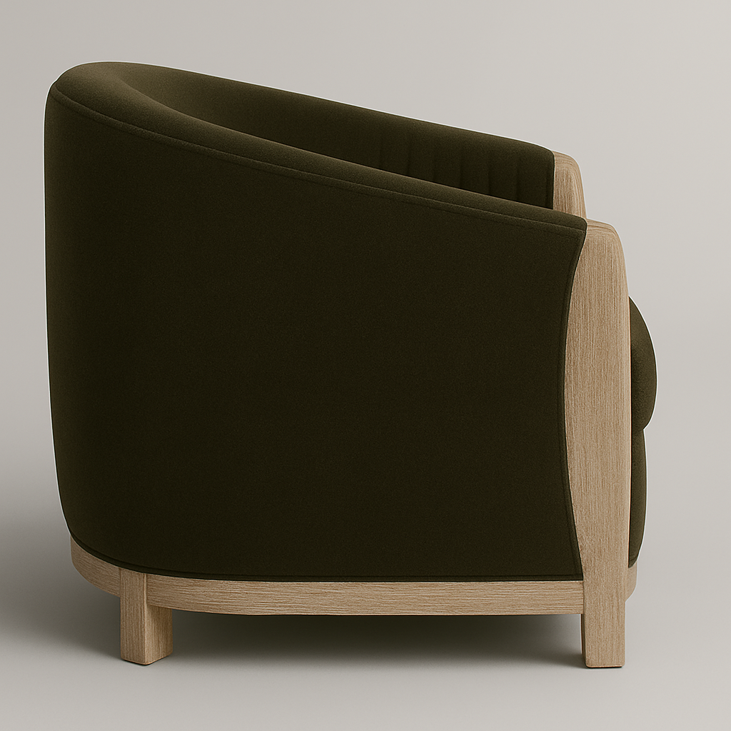 Side view of a modern olive velvet barrel accent chair with a curved full back and cushioned seat, supported by a natural wood frame and low block legs.