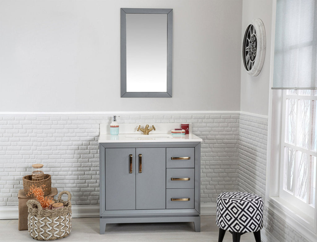 Modern gray solid-wood single-sink vanity with a white stone top, gold-tone faucet and hardware, three drawers and double doors, shown with a mirror above, woven baskets and a patterned stool in a bright bathroom.
