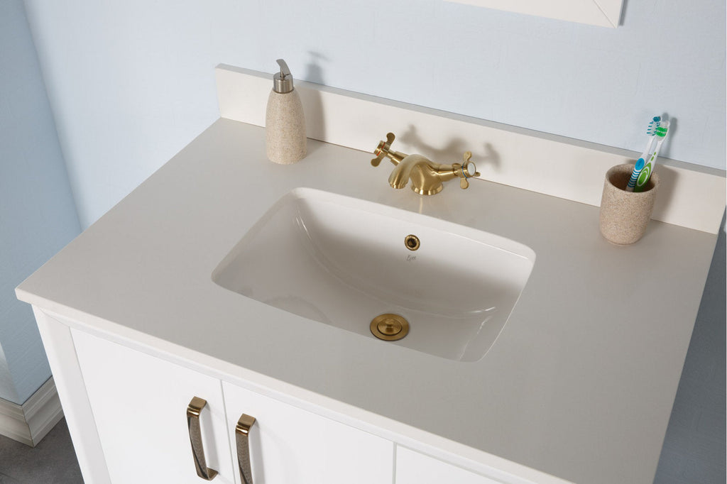 Top-down view of a modern white solid-wood bathroom vanity with a stone-colored countertop, integrated ceramic sink, brass-gold faucet, and stone-textured soap dispenser and toothbrush cup.
