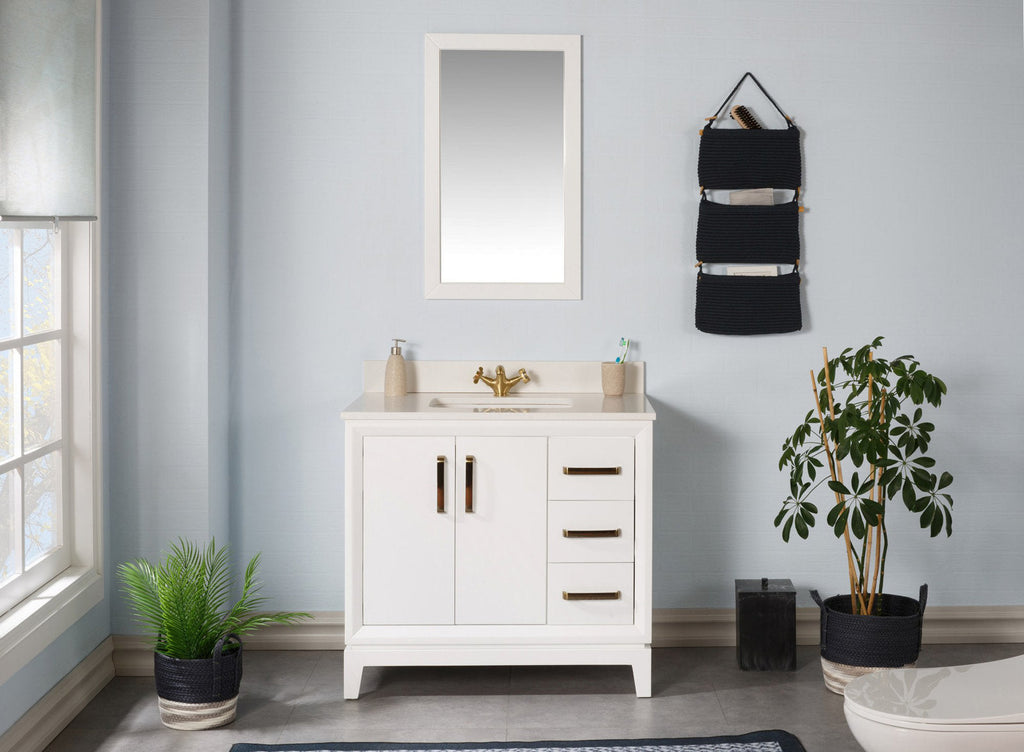 Modern white solid-wood freestanding bathroom vanity with a stone top and integrated single ceramic sink, brass faucet and brass handles; three drawers and cabinet doors shown with a mirror, wall organizer and potted plants.