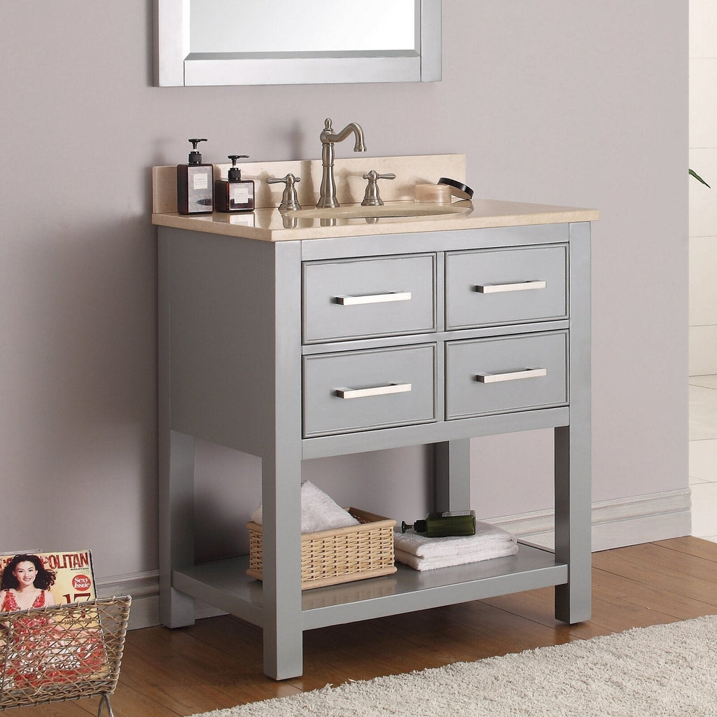Freestanding modern gray solid-wood bathroom vanity with a stone top and integrated ceramic sink, brushed-nickel faucet, four drawers with metal bar pulls and an open lower shelf holding towels and a wicker basket.