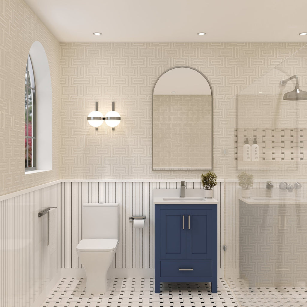 Modern bathroom featuring a navy-blue solid wood single-sink vanity with a stone countertop and ceramic sink, chrome faucet and handles, arched mirror, globe wall sconce, adjacent toilet and glass-enclosed shower on mosaic tile floor.