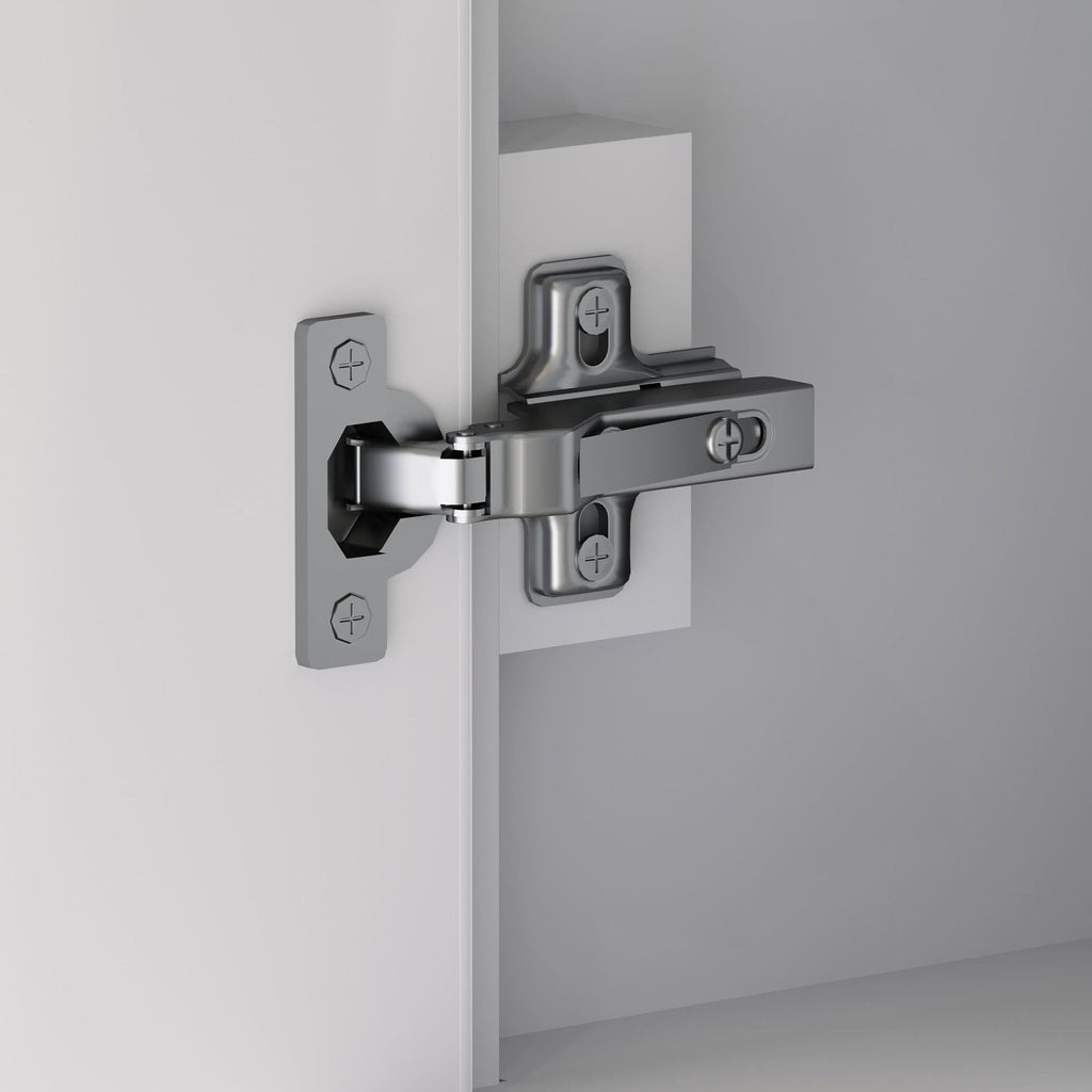 Close-up of a polished chrome concealed cabinet hinge mounted to a stone-colored wooden vanity door and interior, showing the mounting plates, screws and hinge arm.