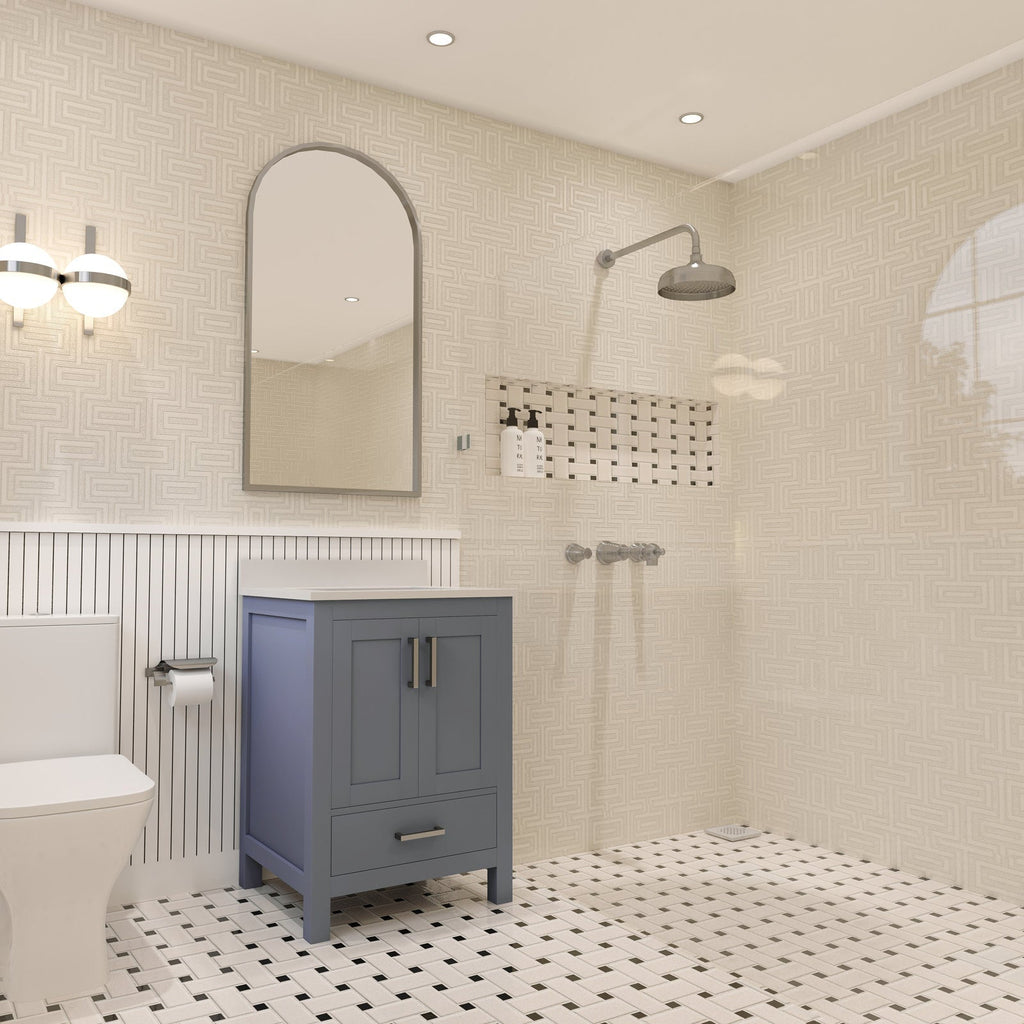 24-inch modern solid-wood bathroom vanity with a white stone top and blue-gray painted cabinet, arched mirror and wall sconce above, toilet at left and tiled walk-in shower with rain showerhead and mosaic niche at right.