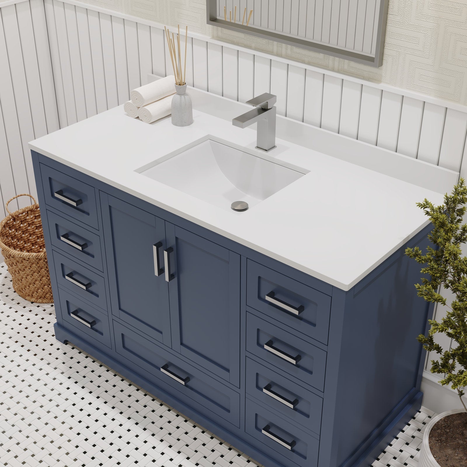 Modern solid wood 48-inch freestanding bathroom vanity with a white stone countertop, integrated rectangular ceramic sink, brushed metal single-handle faucet and multiple storage drawers, styled with rolled towels and wicker basket.