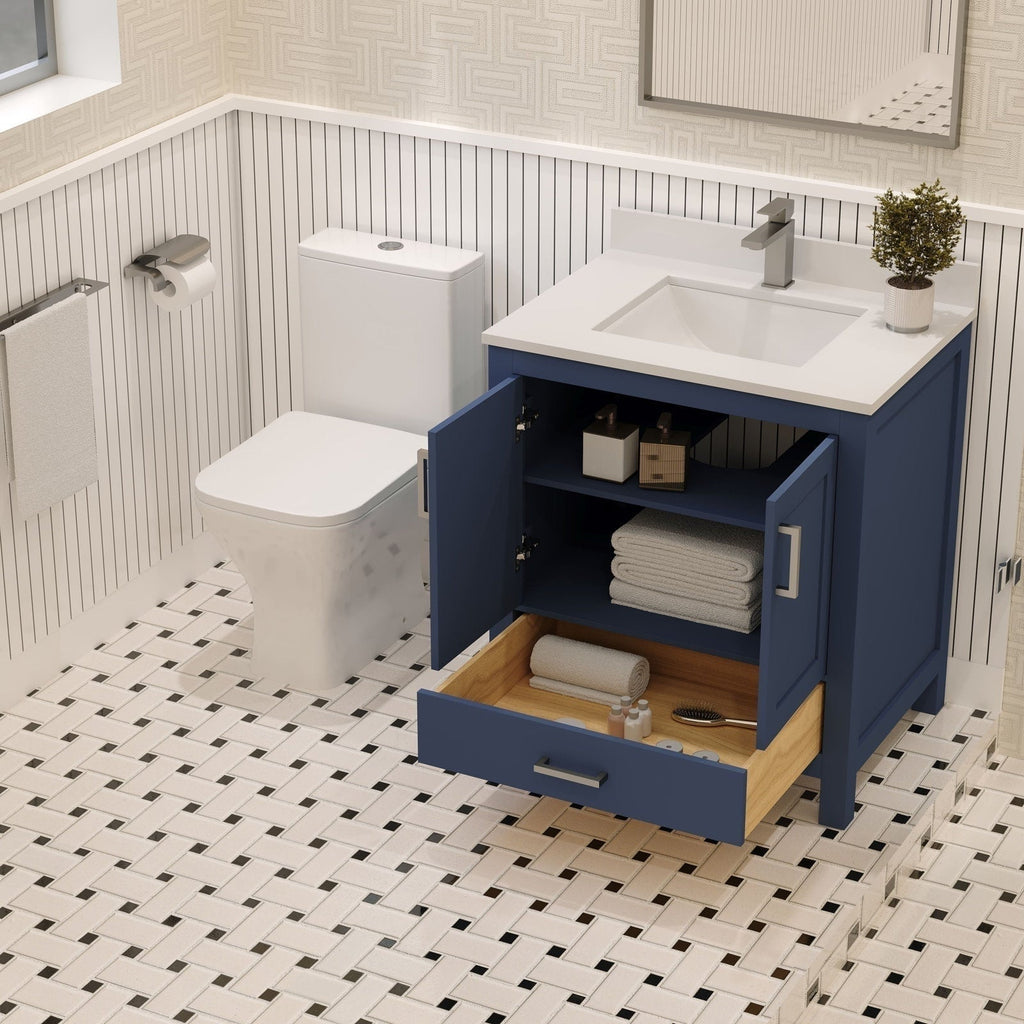 Modern solid wood bathroom vanity with a stone countertop and integrated rectangular sink; open double doors and a pulled-out bottom drawer reveal towels and toiletries, paired with a single-handle faucet, mirror and adjacent toilet on patterned tile