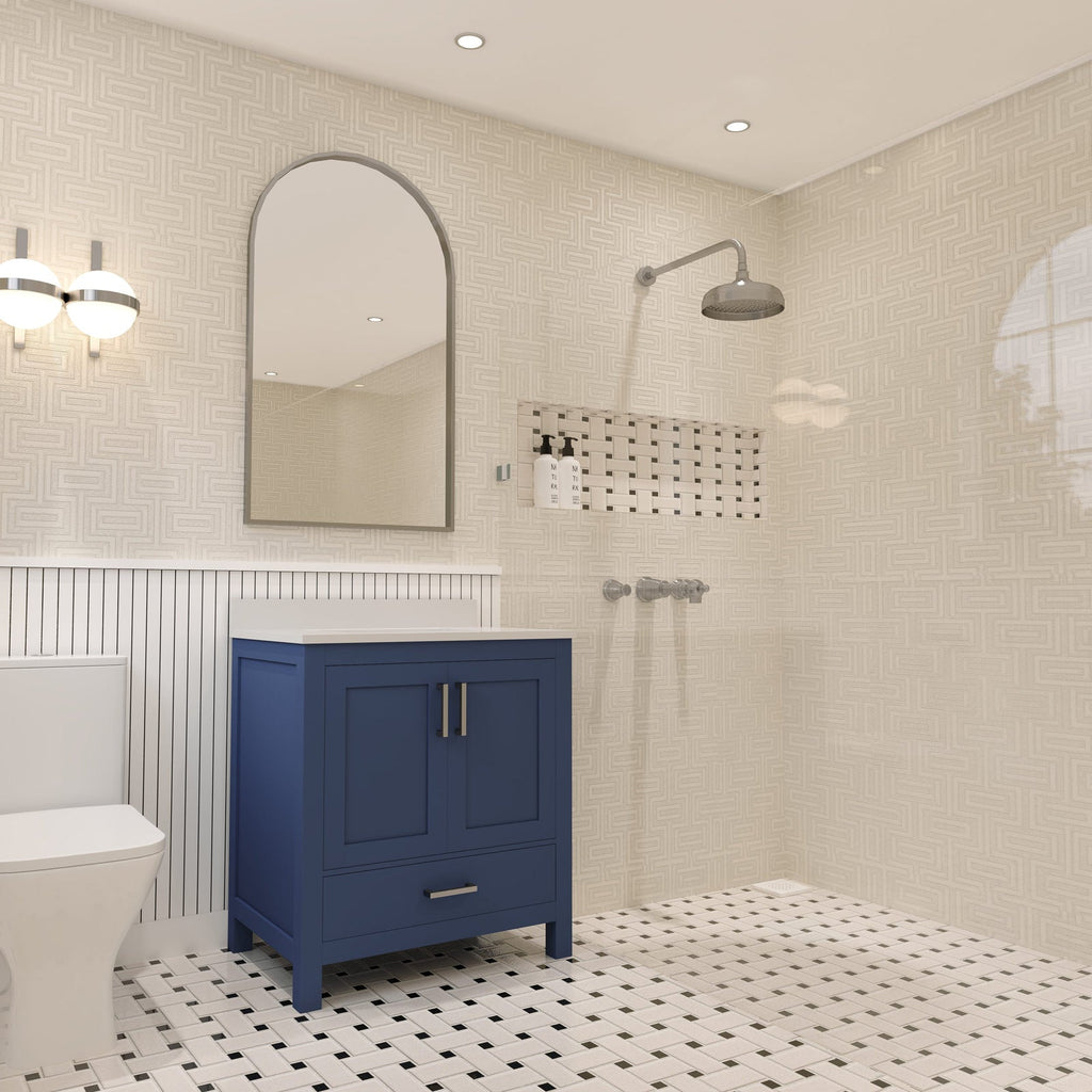 Freestanding navy solid-wood bathroom vanity with a white stone top and brushed metal pulls beneath an arched mirror, shown in a contemporary bathroom with beige patterned tile walls, black-and-white basketweave floor, wall sconce and showerhead.