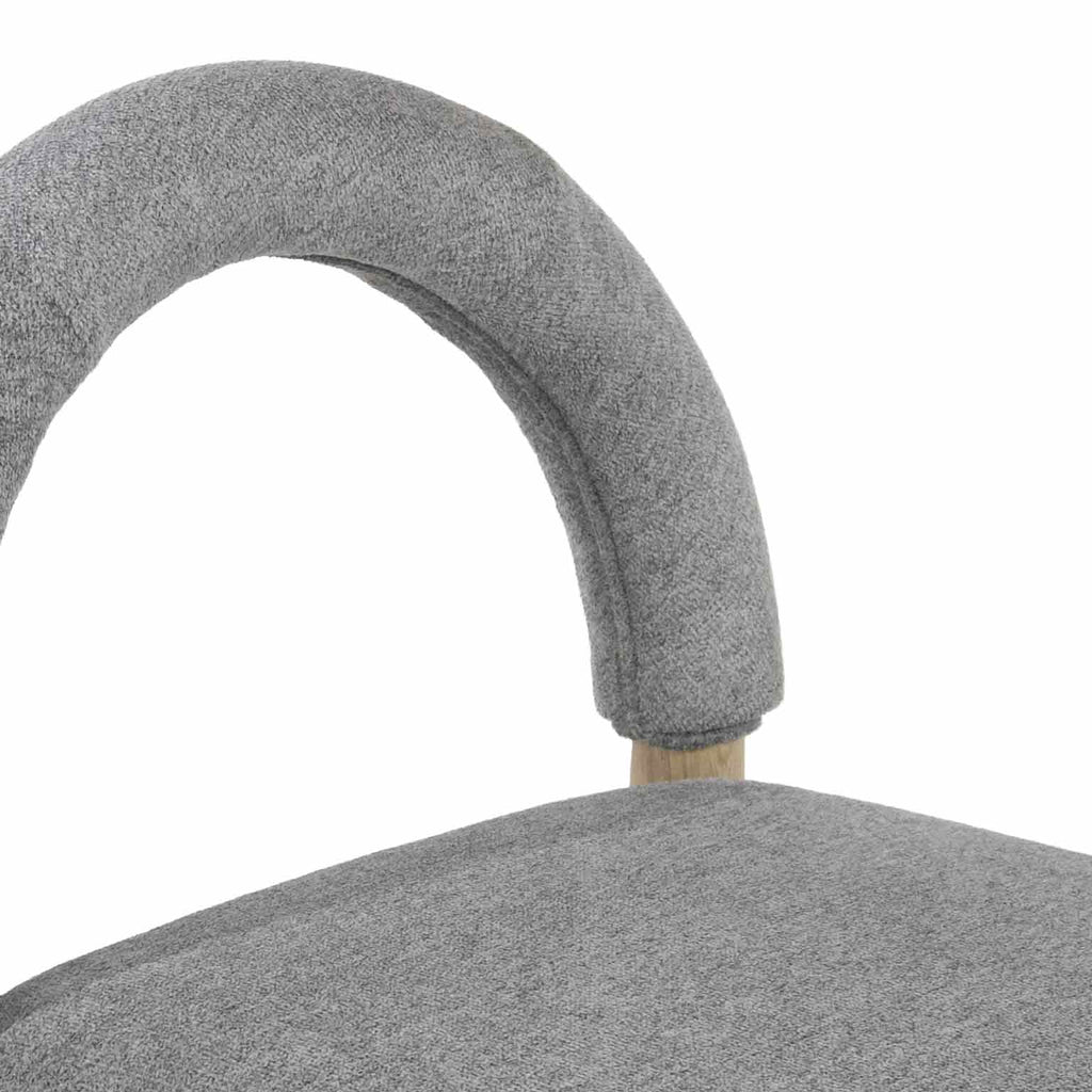 Close-up of a stool’s curved gray boucle upholstered backrest and matching seat top, showing textured boucle fabric and a natural oak frame detail.