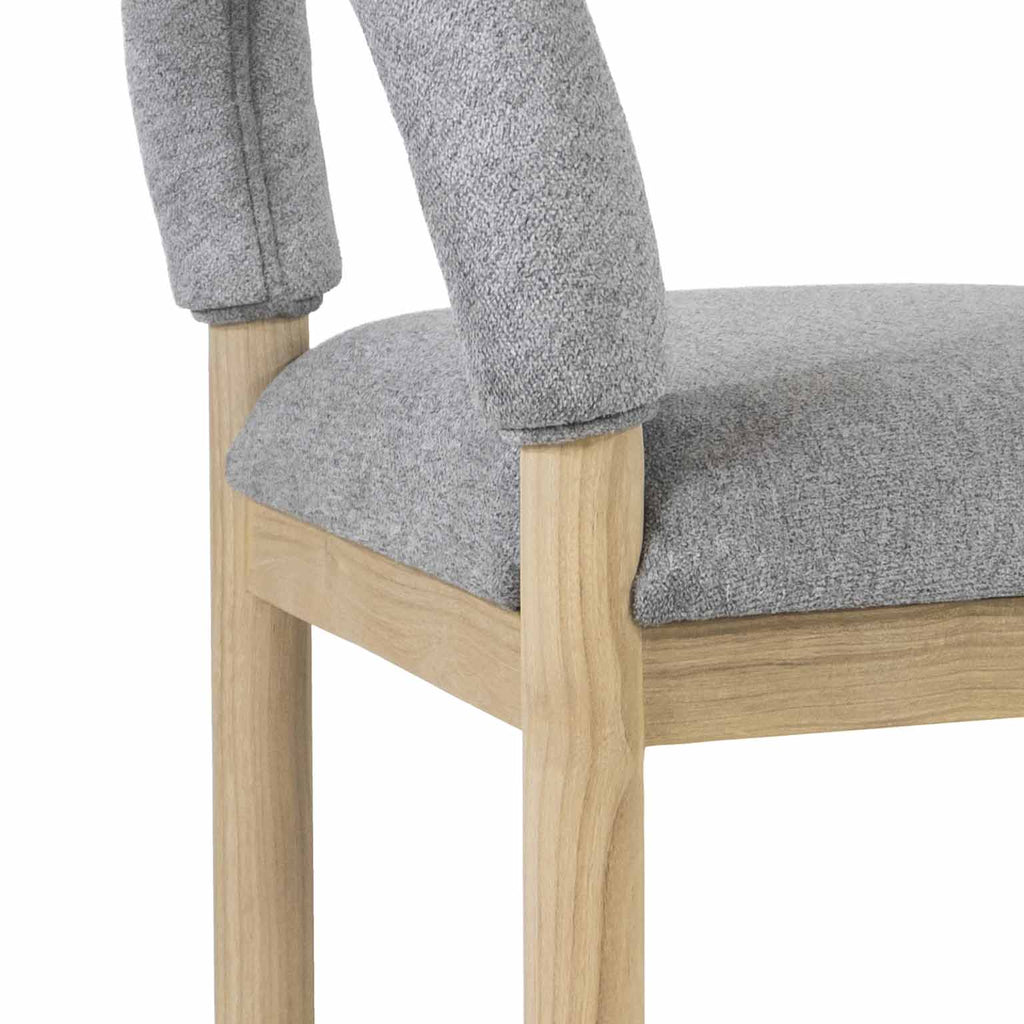 Close-up of a gray boucle upholstered seat and low back mounted on a natural oak frame and legs, highlighting the textured fabric and visible wood grain.