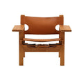Front view of a mid-century modern teak armchair with a solid teak frame, wide flat armrests and tan leather sling seat and back secured by visible leather straps and buckles.