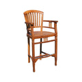 Natural teak outdoor bar stool with a curved slatted back, armrests, rectangular wooden seat and integrated footrest; solid wood coastal-style bar stool ideal for a patio or outdoor bar.