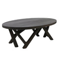 Oval solid wood coffee table in a mahogany smoked-black finish, with a thick top and sculptural crisscross legs for a modern contemporary living room.