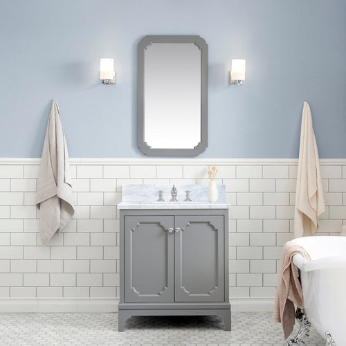 Contemporary gray solid-wood single-sink vanity with Carrara white marble countertop and chrome faucet, gray framed mirror above, subway tile wainscot, wall sconces, hanging towels and a partial clawfoot tub view.