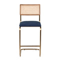 Front view of a cantilever bar stool with a navy velvet upholstered seat, natural woven cane back in a wood frame, and a gold-brass metal cantilever base with integrated footrest.