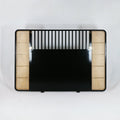 Boho-style king headboard in black metal and oak with natural rattan cane panels on both sides, vertical slat detailing across the top and a solid black central panel.