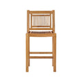 Armless teak outdoor bar stool in a natural finish featuring a slatted seat and vertical slat back, solid wood frame with integrated footrest, coastal-style design shown on a white background.