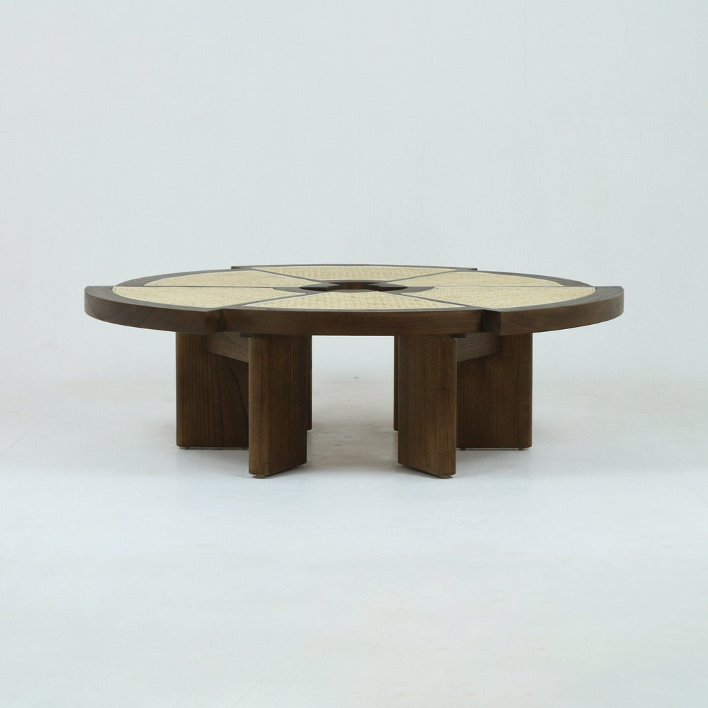 Low round coffee table in natural oak with woven cane inset top divided into radial segments, supported by thick solid-wood pedestal legs, showcasing a minimalist mid-century modern silhouette.