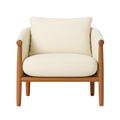 Front view of a cream boucle upholstered accent chair with a plush seat cushion, loose back pillow and a natural wood frame with rounded arm posts and tapered legs.