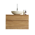 Natural teak floating bathroom vanity with two wood-grain drawers and a cream stone round vessel sink, chrome tall faucet and two bottles on top, modern single-sink contemporary design.