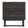 Front view of a black wooden two-drawer nightstand with a white marble top, framed drawer fronts, centered round gold knobs, and turned legs connected by a stretcher.