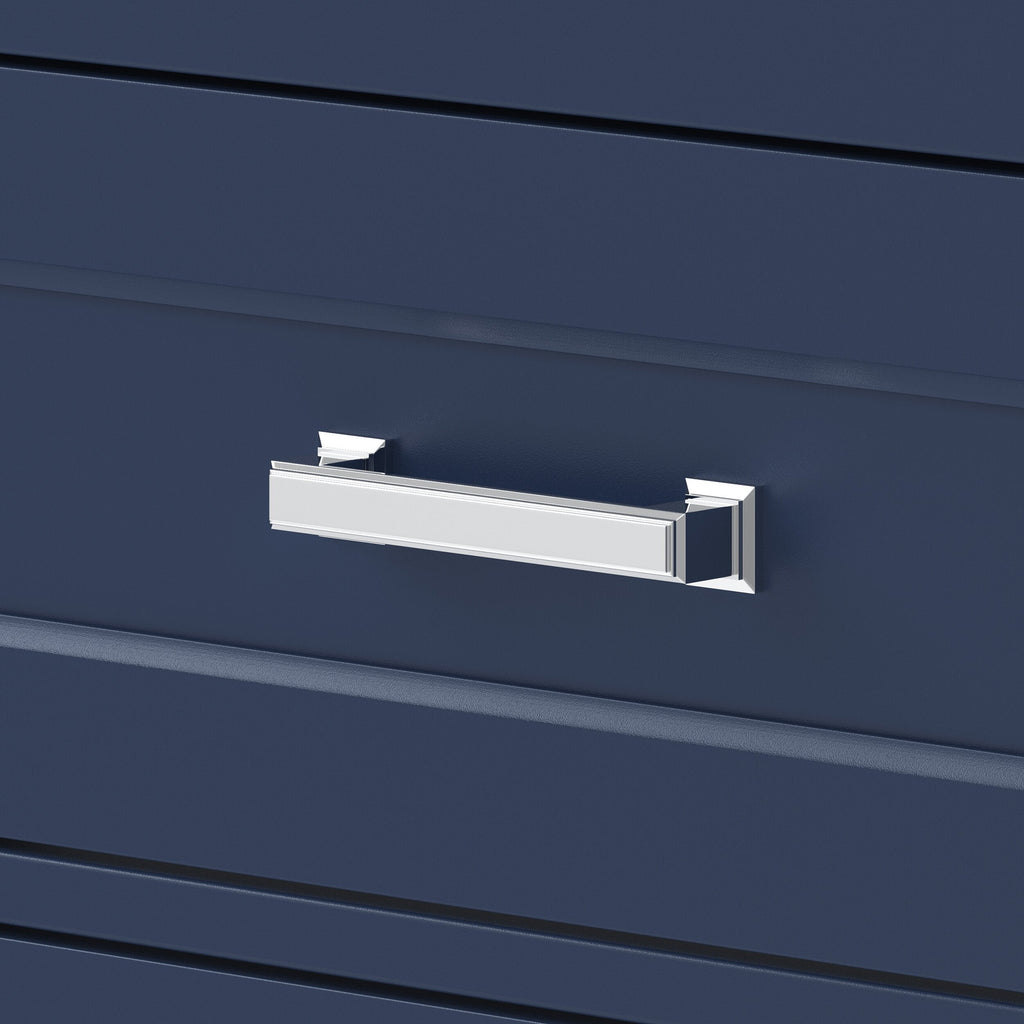 Close-up of a polished chrome rectangular drawer pull mounted on a deep navy wood vanity drawer front, showing beveled edge details and contemporary glam styling.
