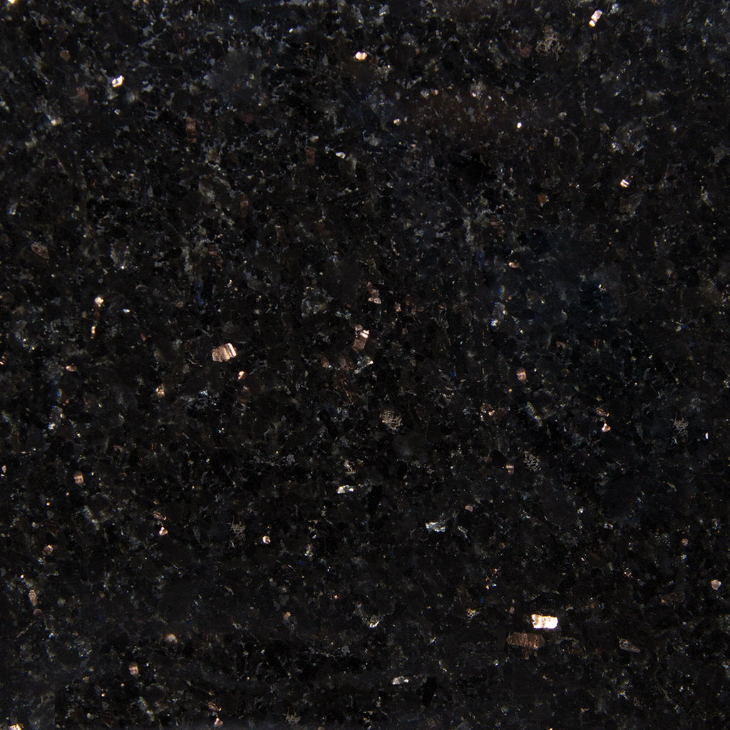 Close-up of a polished black quartz countertop surface showing scattered reflective metallic and gray mineral flecks