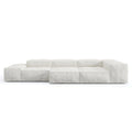 Low-profile modular sofa upholstered in loose white linen with deep cushioned block seats, wide low arms and a subtle wooden base, shown against a plain white background.