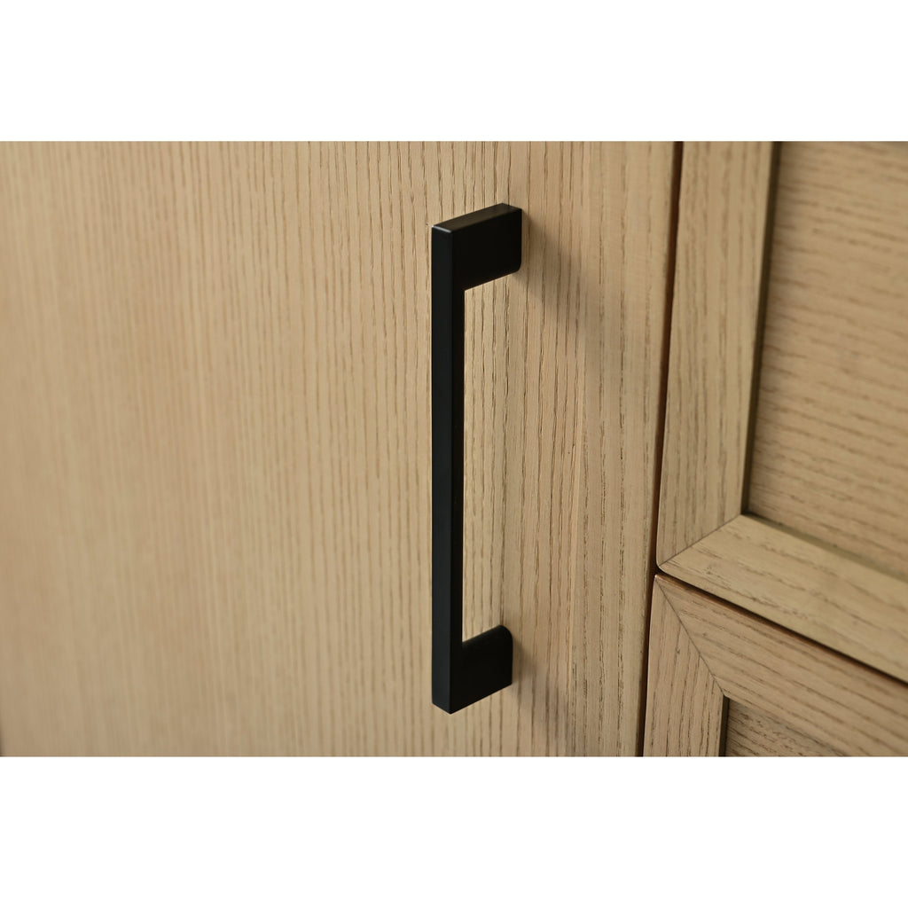 Matte black rectangular cabinet pull mounted vertically on a light stone-colored solid wood vanity door, showing wood grain texture and the adjacent recessed panel edge.