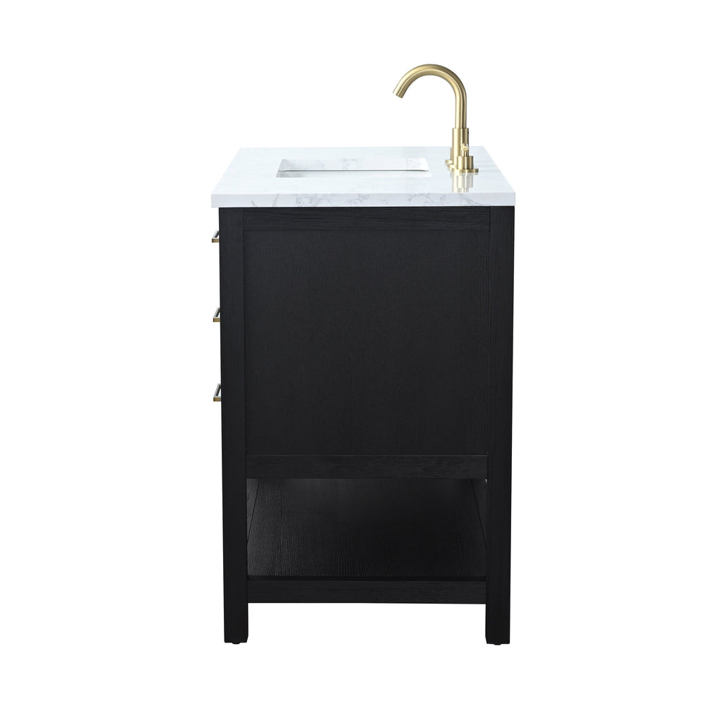 Side view of a modern black solid wood bathroom vanity with a white marble stone top, integrated rectangular sink, open lower shelf, and brass faucet with matching brass drawer pulls.