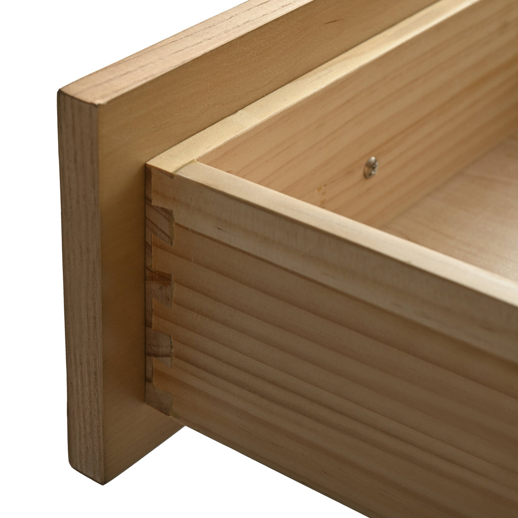 Close-up of a light solid wood drawer corner showing dovetail joinery, natural wood grain and an interior mounting screw, highlighting the vanity's craftsmanship and construction detail.