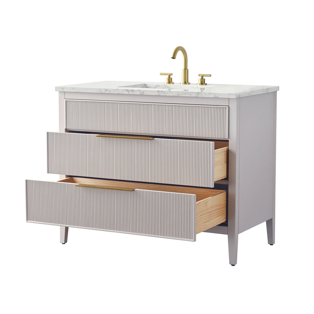 42-inch single-sink modern bathroom vanity with white stone top, light stone-gray solid wood cabinet, two ribbed-front drawers partially open revealing natural wood interiors, and brass-finish faucet and bar handles.