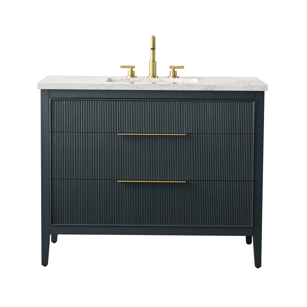 Freestanding 42-inch modern solid wood bathroom vanity in a dark stone-toned finish with vertical fluted drawer fronts, white stone countertop with integrated rectangular ceramic sink, and brushed brass faucet and long brass pulls.