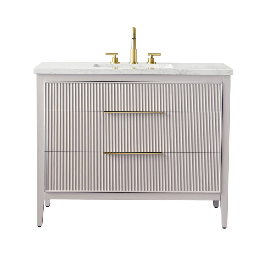 42-inch modern freestanding single-sink bathroom vanity with a stone-look marble top, undermount rectangular ceramic sink, solid wood fluted taupe cabinet with two wide drawers and long brushed brass handles and faucet.