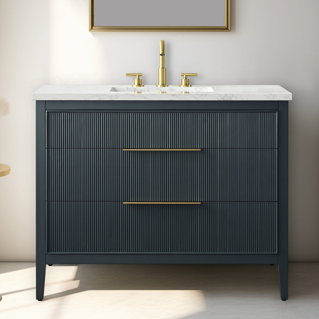 42-inch modern solid wood single-sink bathroom vanity with white stone top, integrated rectangular sink, fluted dark drawer fronts, and brass faucet with slim brass drawer pulls.