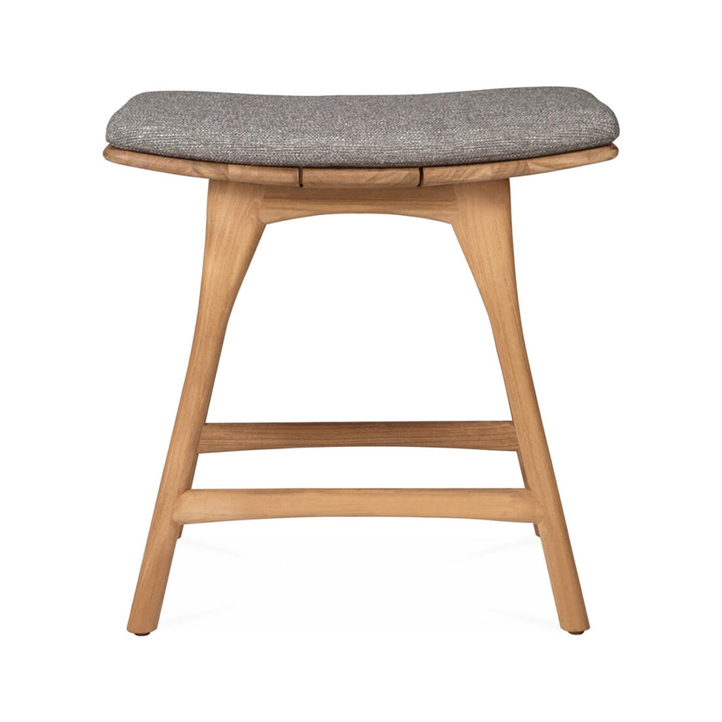 Front view of a coastal backless shower stool in natural teak with tapered legs, two horizontal stretchers and a neutral gray upholstered seat cushion.
