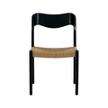 Armless mid-century dining chair with a black teak wood frame and curved backrest, featuring a woven natural rattan seat in tan.
