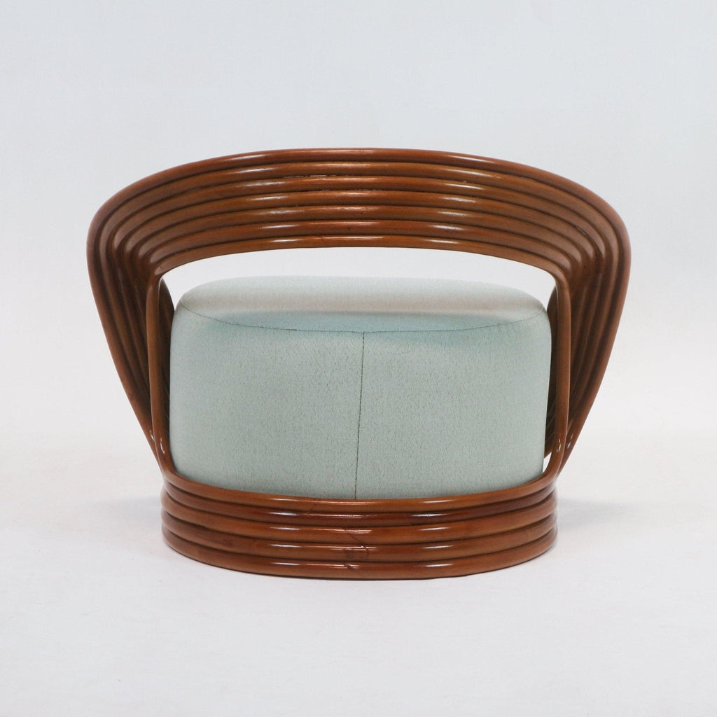 Front view of a mid-century modern lounge chair with mint-green fabric upholstery and a curved brown cane rattan frame that wraps the base and open back.