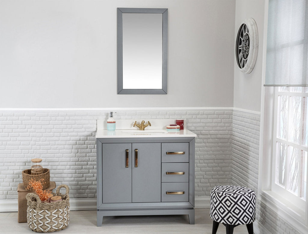 Modern gray solid-wood single-sink vanity with a white stone top, gold-tone faucet and hardware, three drawers and double doors, shown with a mirror above, woven baskets and a patterned stool in a bright bathroom.