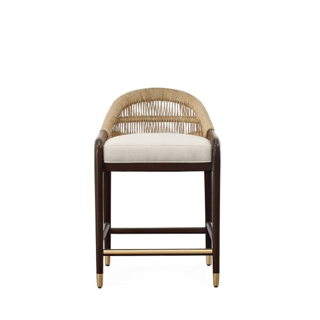Front view of a teak-framed counter stool with woven rope back, cream upholstered seat, dark-stained wood legs and a brass footrest with brass-capped legs.