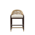 Front view of a teak-framed stool with woven rope back, beige upholstered seat cushion, dark teak legs and a brass footrest and leg caps.